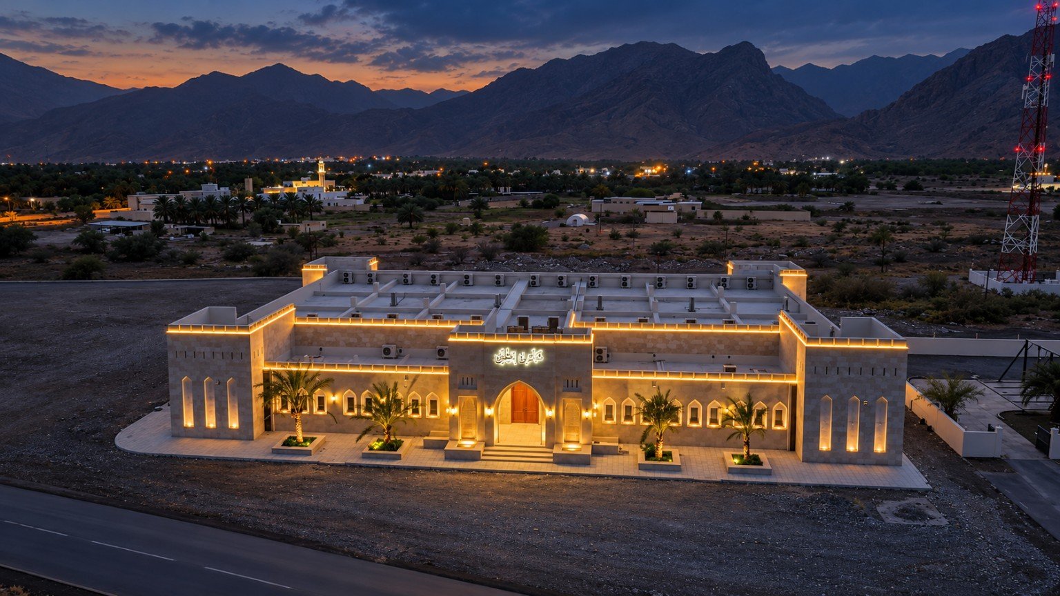 Completed Imti Public Majlis exterior with warm lighting on stone arches and roof edges